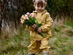 Pige klædt i Mikk-Line regnsæt i ratan med seler og lynlås